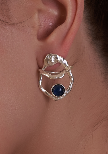 Silver earring with a blue gemstone worn on an ear | Statement Earring | neo jewelry