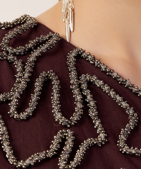 Close-up of a Coca cola with silver beaded detailing and a matching earring. | Women Dresses | Pret Clothes | nEo Clothes.