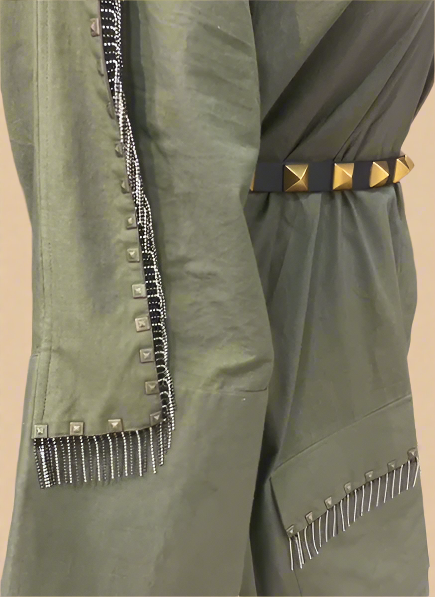 Olive green shirt dress close-up showing metallic sleeve embellishment, hanging bead details, and black-and-gold studded waist belt. | Women's Dress | Pret Clothes | Asymmetrical Dress | nEo Clothes