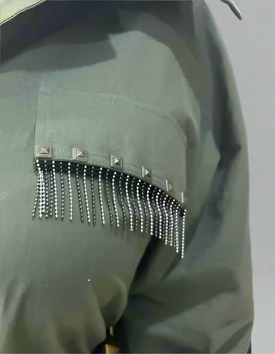 Olive green shirt dress sleeve close-up with square metallic studs and dangling bead fringe, highlighting edgy designer craftsmanship.  | Women's Dress | Pret Clothes | Asymmetrical Dress | nEo Clothes