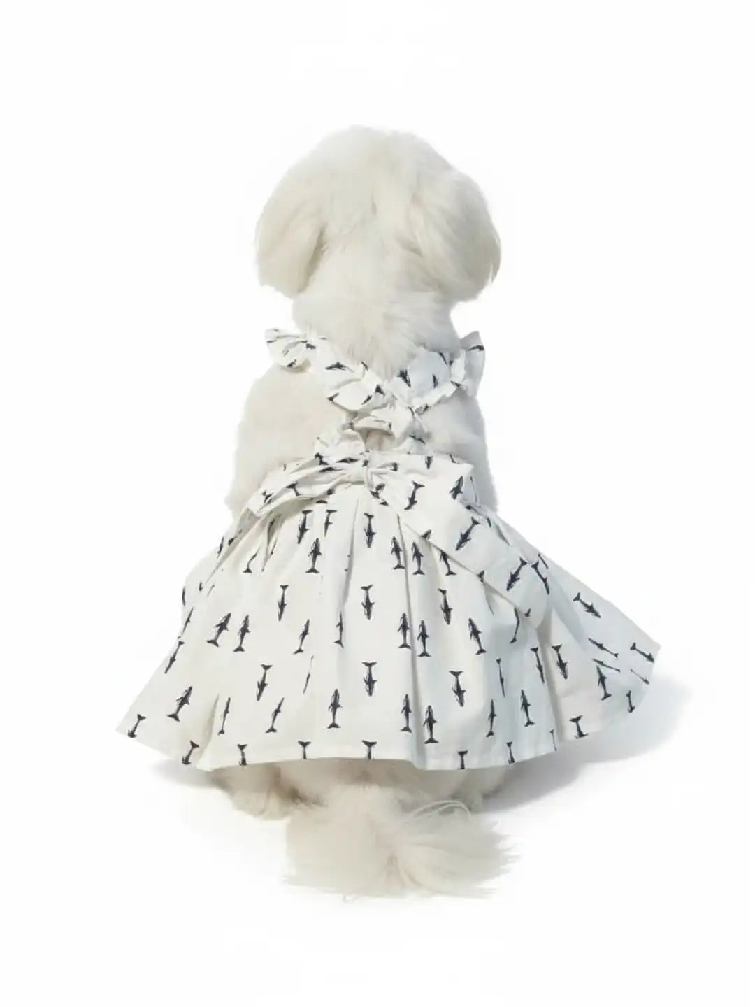 Dog wearing a white dress with black patterns 