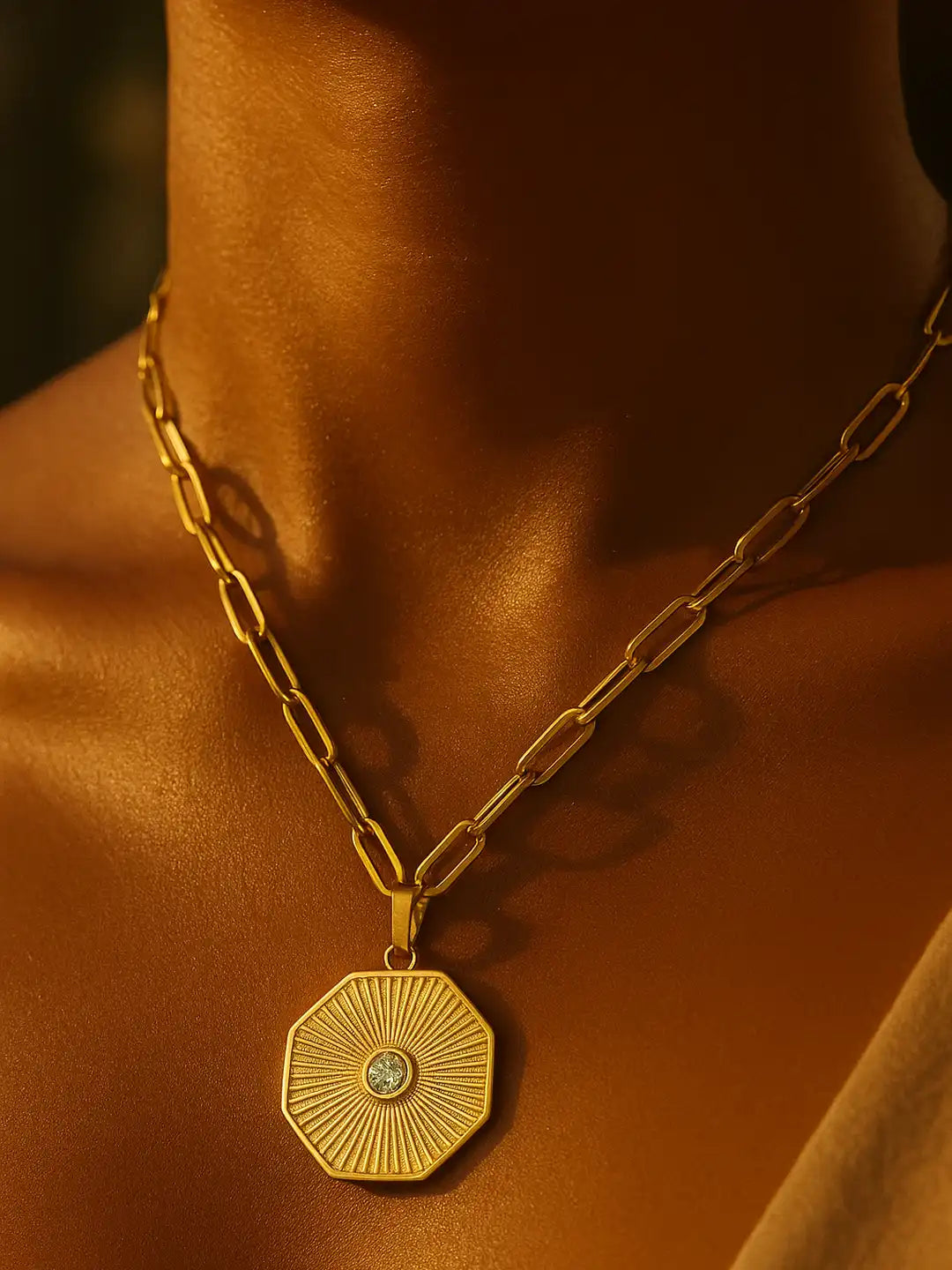 Gold necklace with a hexagonal pendant on a person 