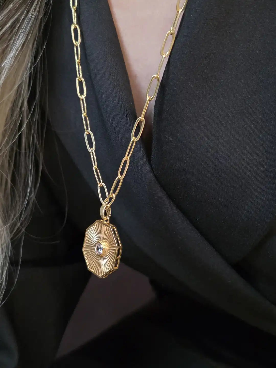 Gold necklace with a pendant.