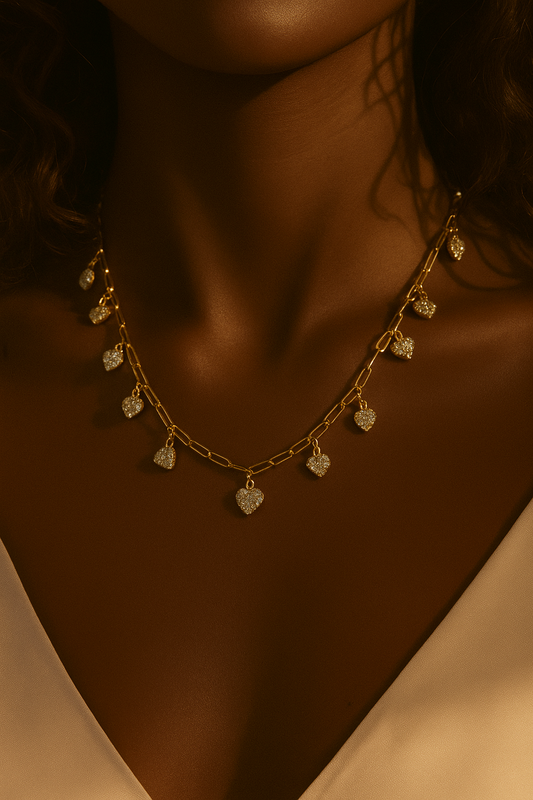Model wearing gold teardrop charm necklace with warm editorial lighting, highlighting the necklace’s shimmer and refined detailing by Near Earth Object.