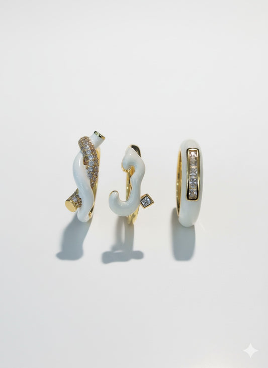 White enamel and gold sculptural rings with crystal-studded abstract shapes, designed in a contemporary artistic style by Near Earth Object.