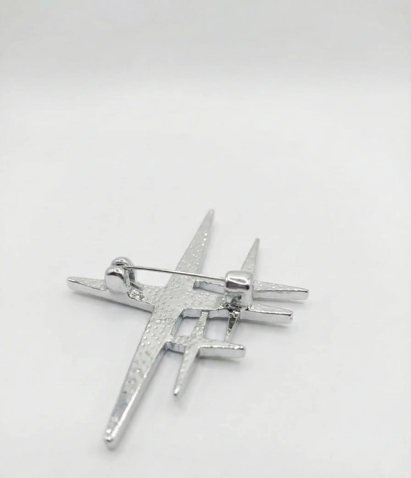 Silver star-shaped brooch on a white background
