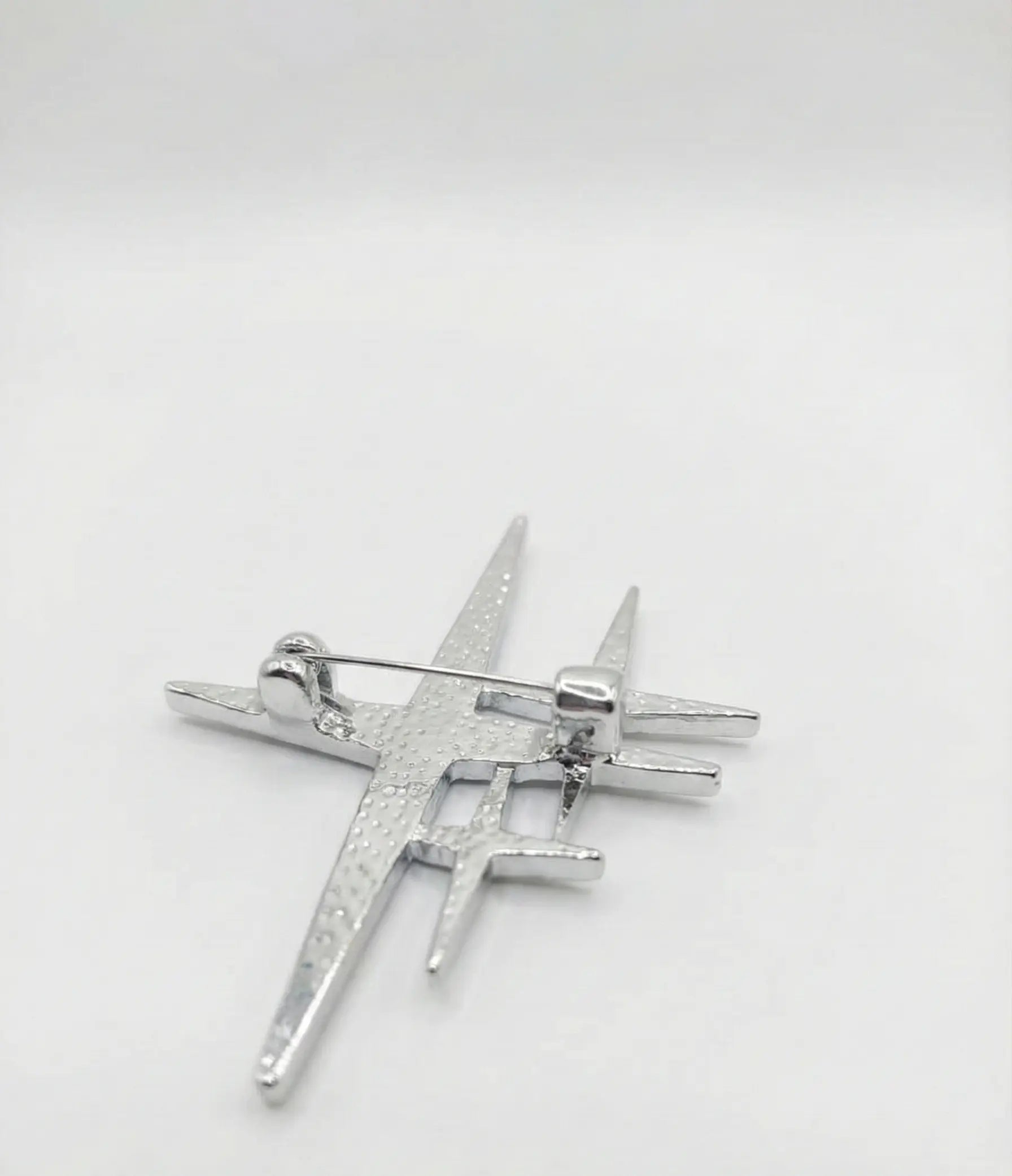 Silver star-shaped brooch on a white background