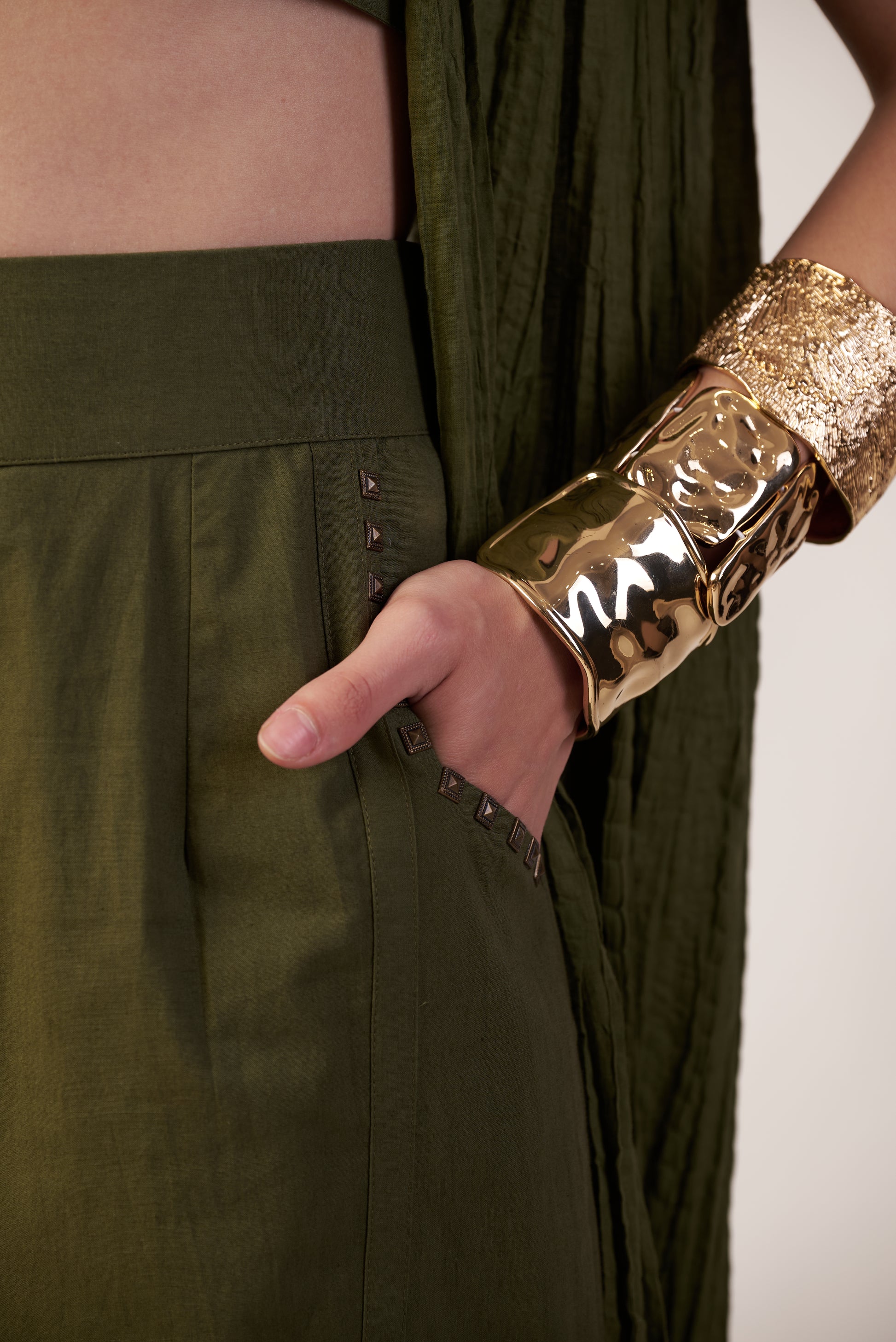 Person wearing a military green pant with a gold metallic hand cuff  | Women's Pants | Bottoms | Pret Clothes | nEo Clothes.