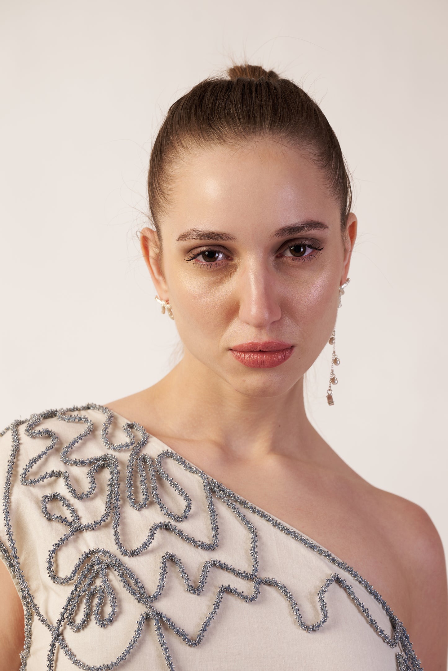 Woman wearing a one-shoulder beaded dress | Women Dresses | Pret Clothes | nEo Clothes.