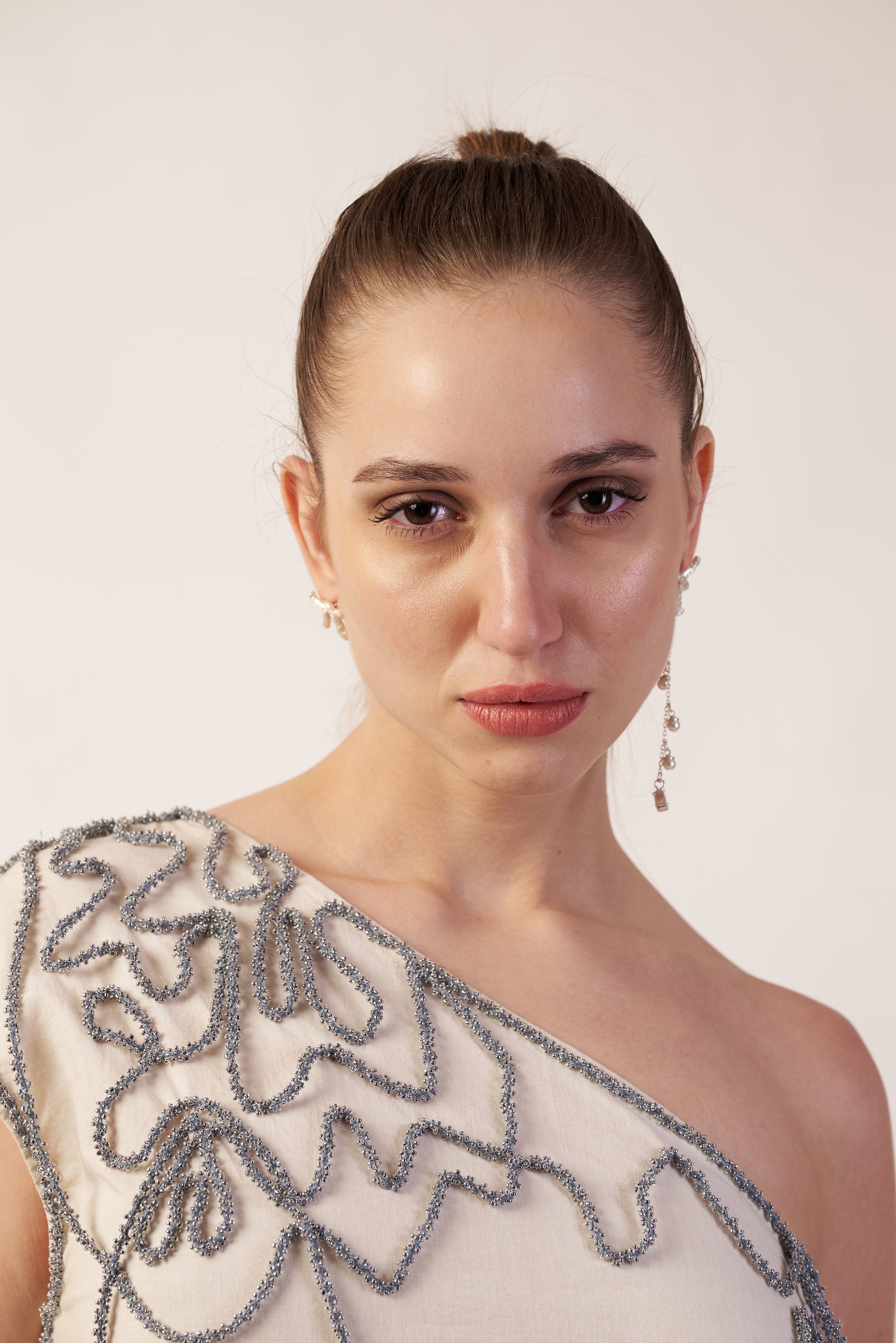 Woman wearing a one-shoulder beaded dress | Women Dresses | Pret Clothes | nEo Clothes.