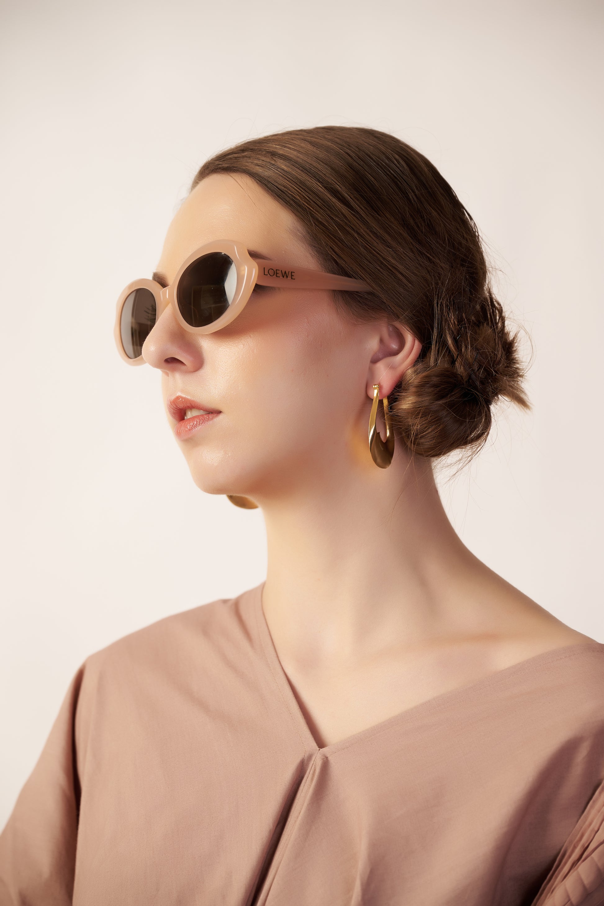 Woman wearing sunglasses and a beige top with Earrings | Women Dresses | Pret Clothes | nEo Clothes.