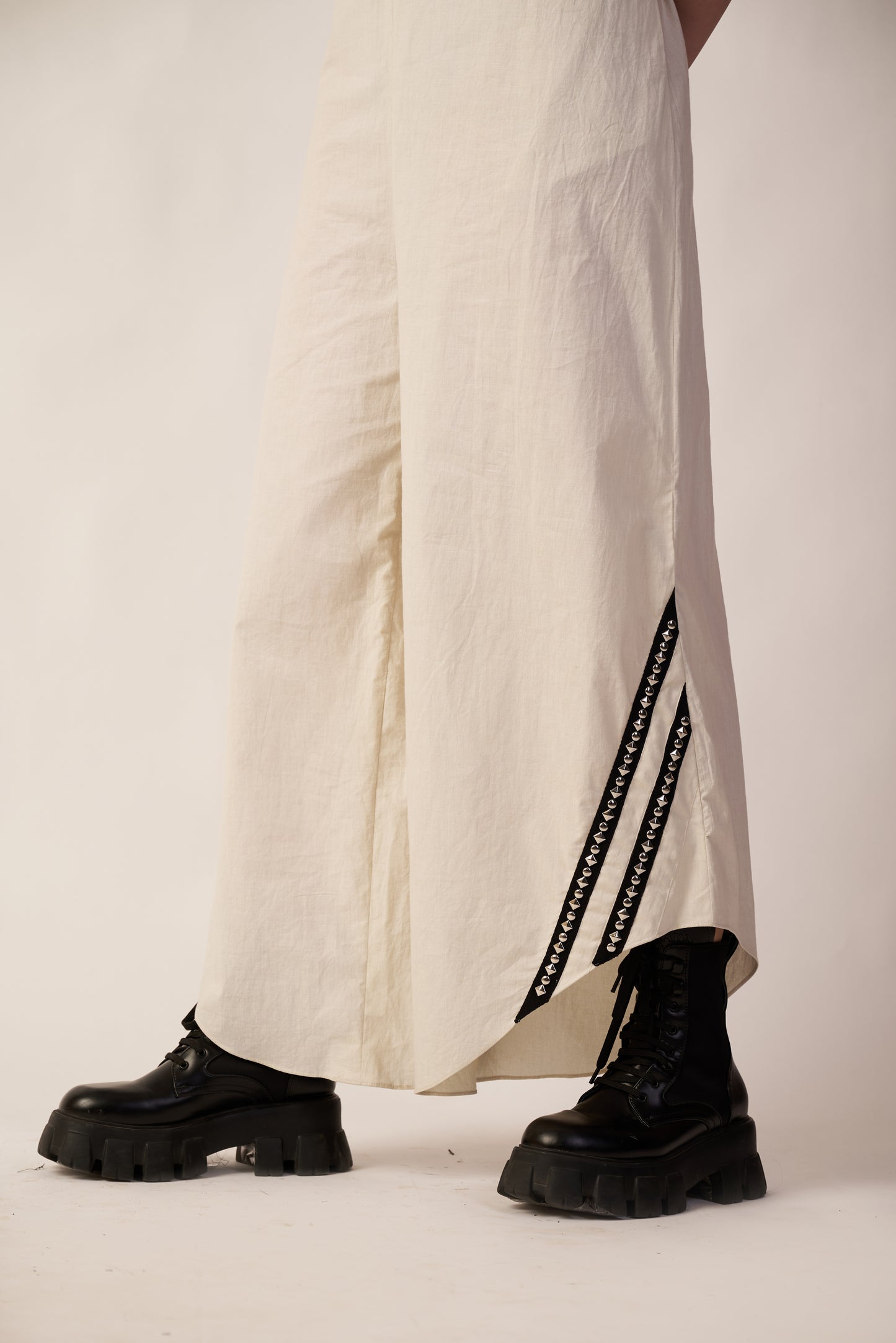 Person wearing black boots and a white dress with black stripes | Women Jumpsuit | Pret Clothes | nEo Clothes.