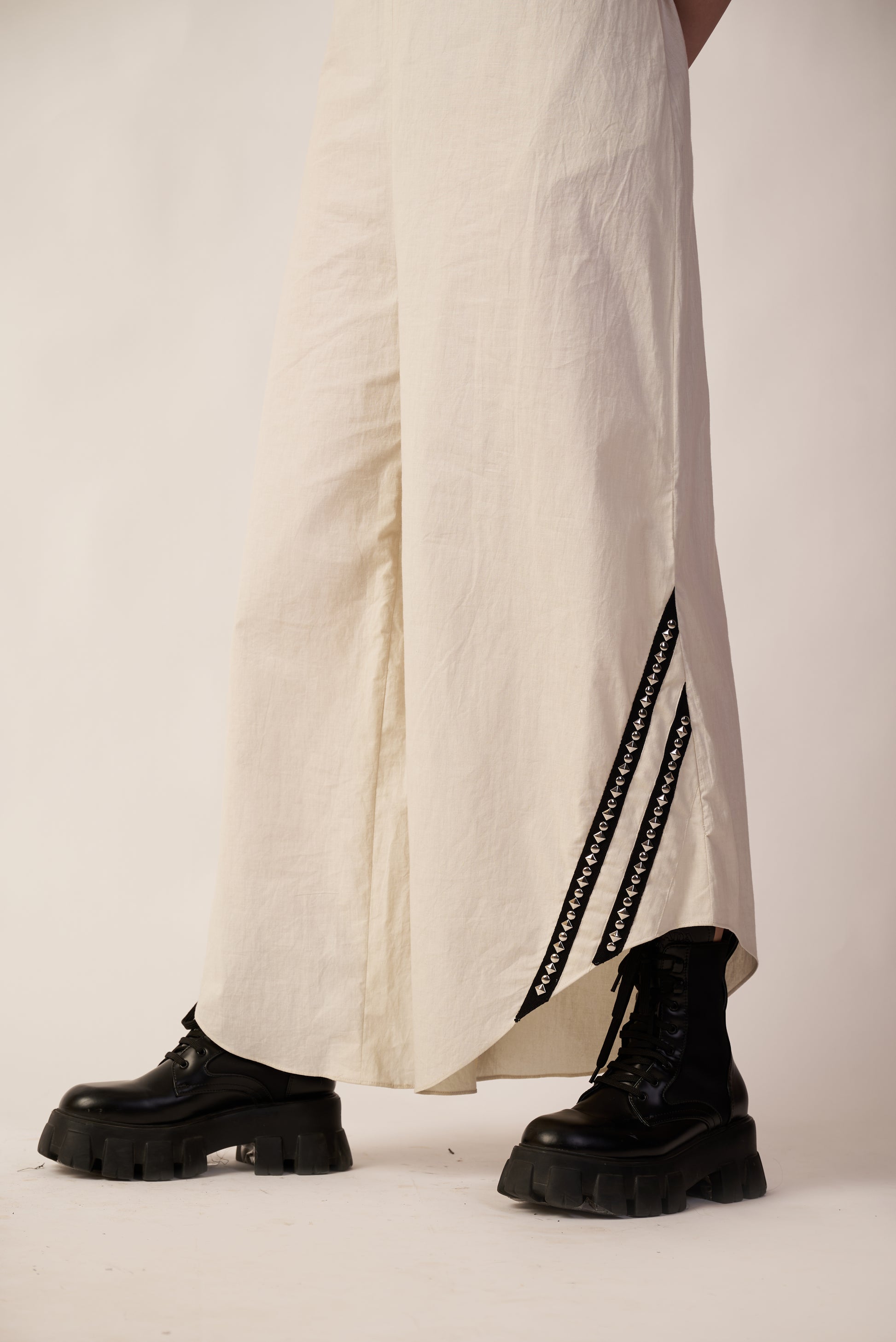 Person wearing black boots and a white dress with black stripes | Women Jumpsuit | Pret Clothes | nEo Clothes.