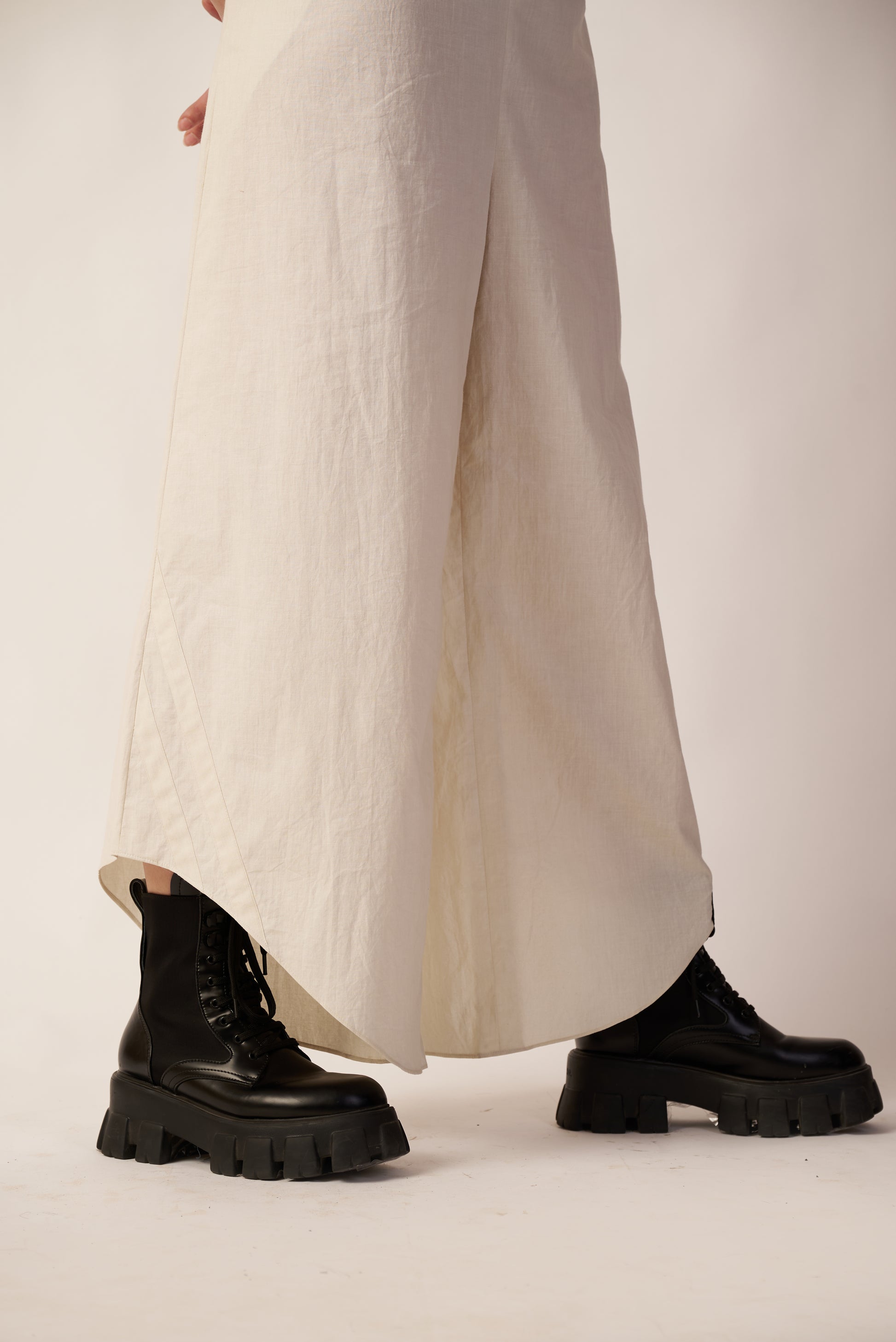 Person wearing black platform boots and beige wide-leg pants | Women Jumpsuit | Pret Clothes | nEo Clothes.