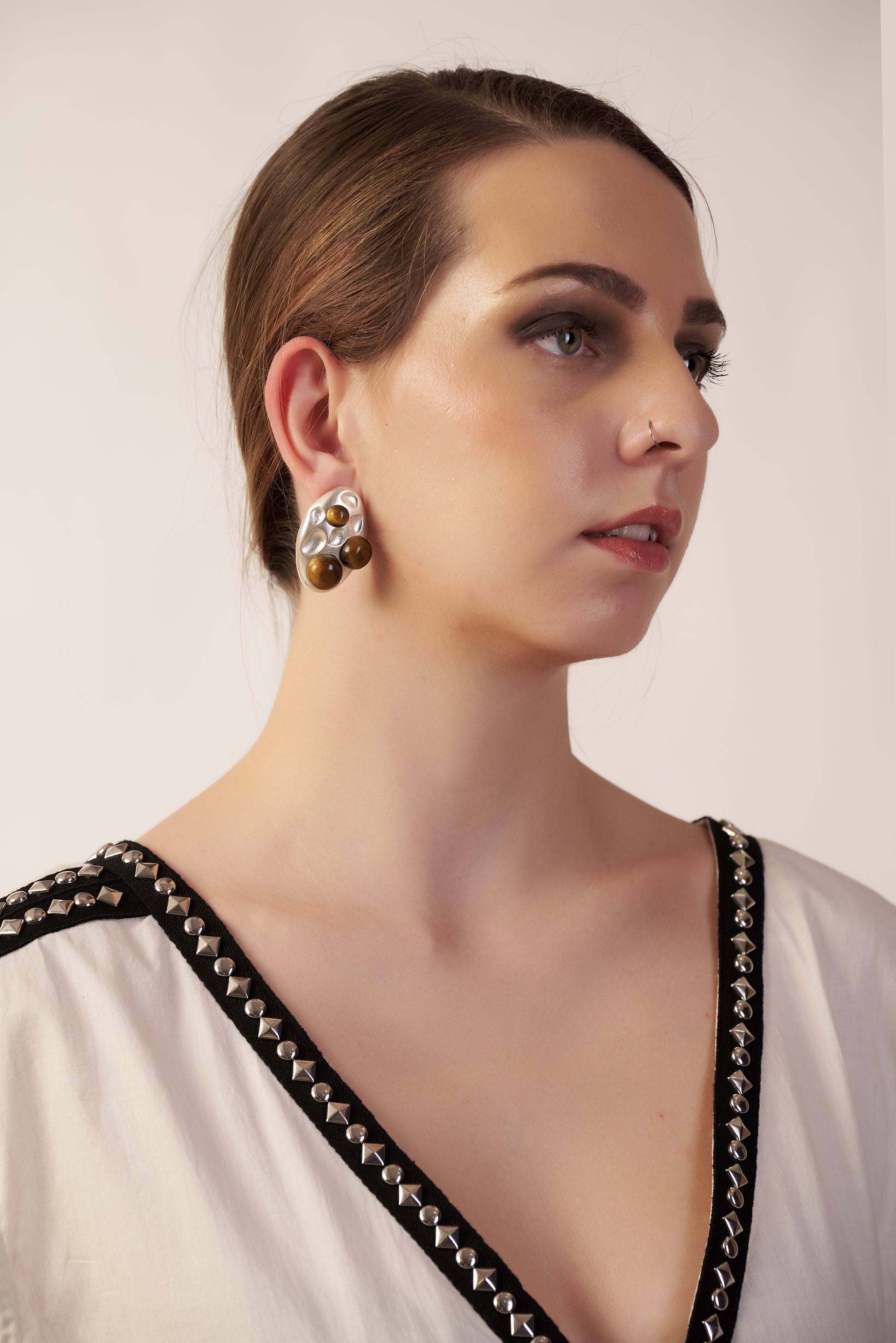 Woman wearing a white top with black detailing and gold earrings  | Women Jumpsuit | Pret Clothes | nEo Clothes.