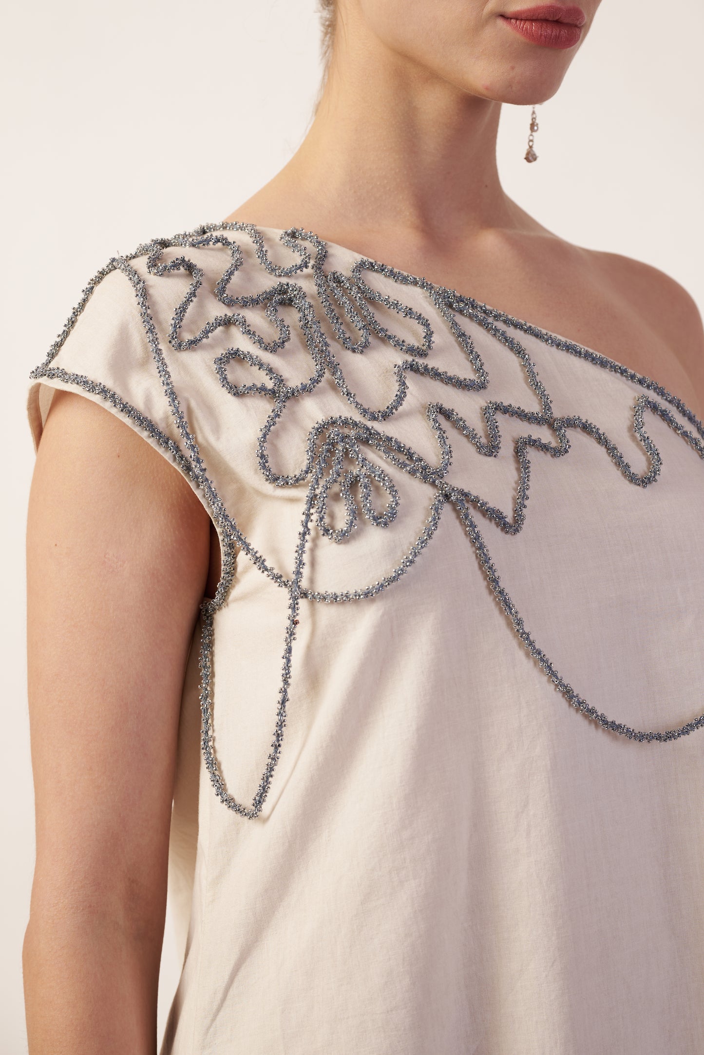 Close-up of a white dress with intricate silver beading  | Women Dresses | Pret Clothes | nEo Clothes.