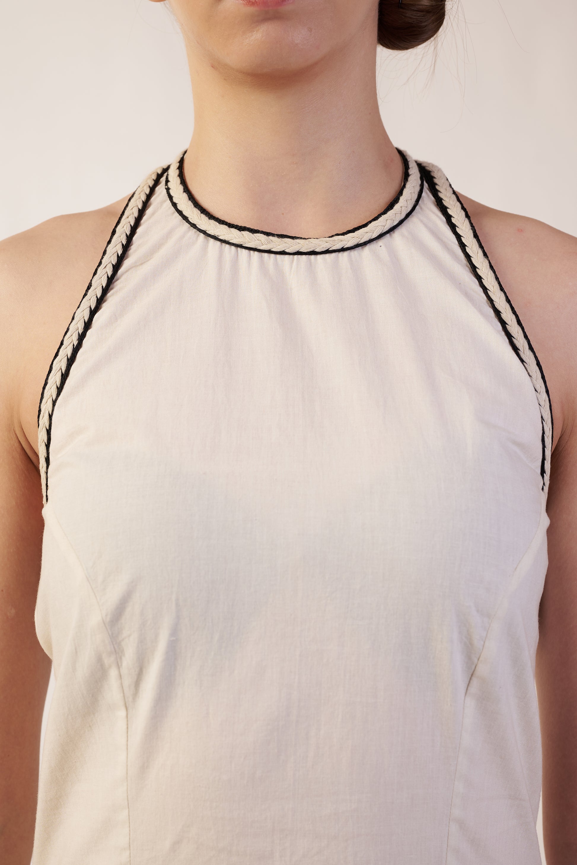 White sleeveless top with black trim worn by a person | Women Dresses | Pret Clothes | nEo Clothes.