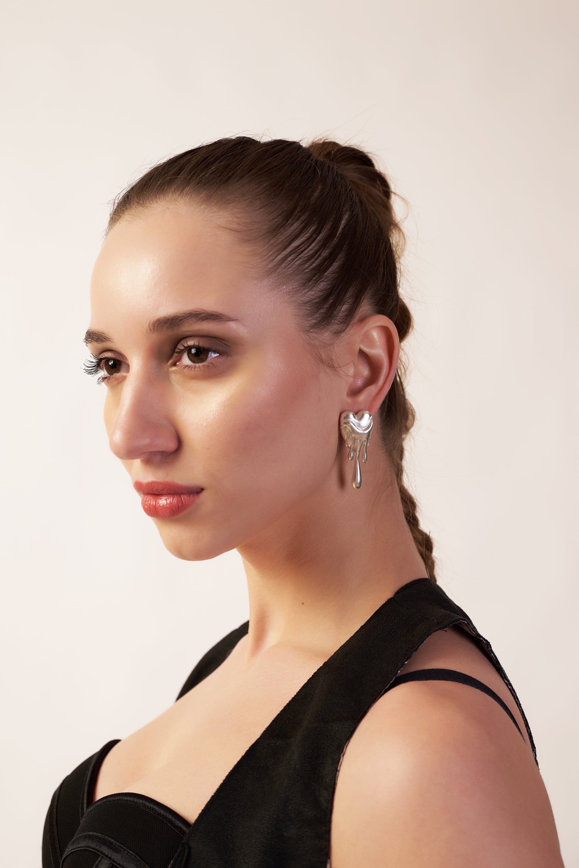 Woman with styled hair and wearing trendy molten heart shape earrings | Statement Ear Cuffs | neo jewelry 