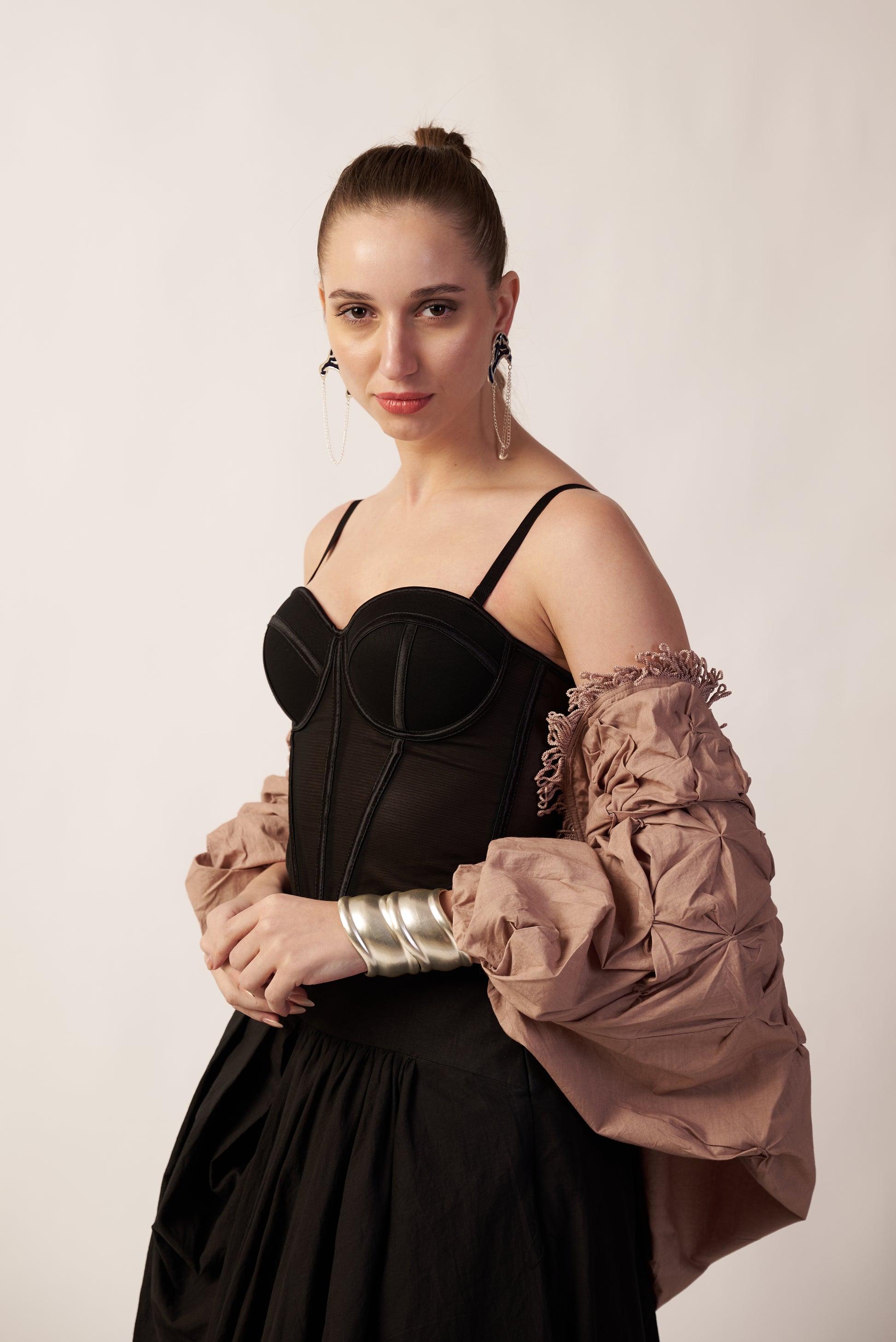 Woman wearing a black dress with a beige jacket with wearing silver hand cuffs | Statement Handcuff | Bracelet | neo jewelry 