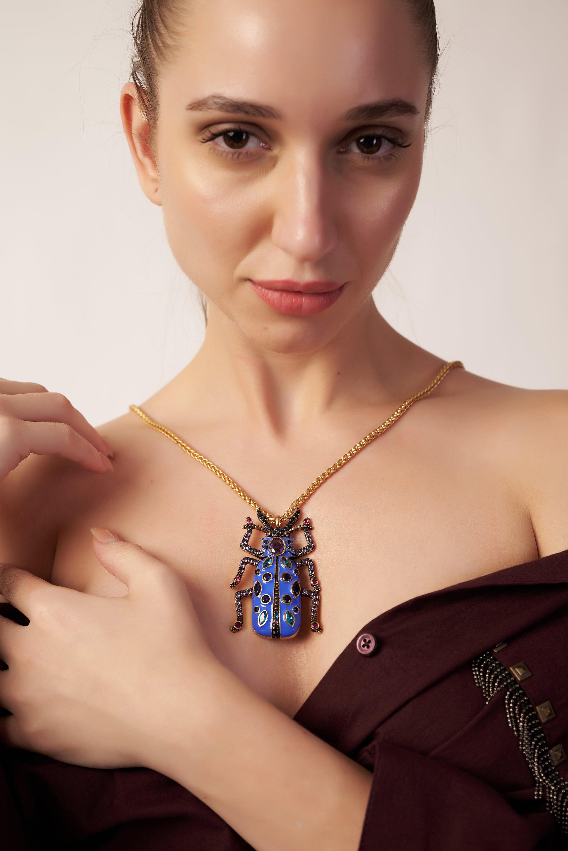 Woman wearing a gold necklace with a blue pendant  | Statement Necklace & Chokers  | neo jewelry 