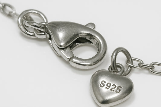 Silver necklace clasp detail with engraved charm tag – premium micro-bead bracelet by Near Earth Object.