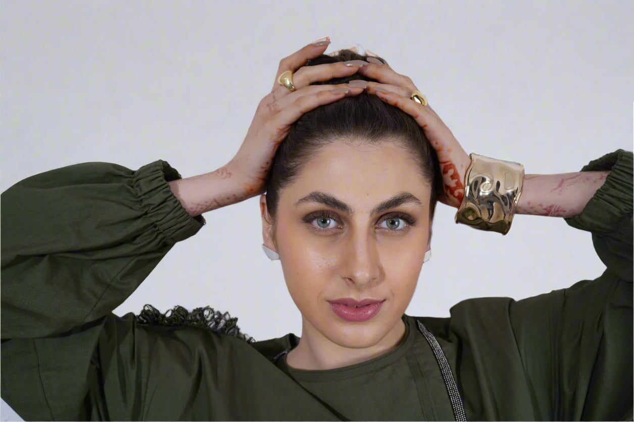 Person wearing a green outfit with gold jewelry | Statement Handcuff | Bracelet | neo jewelry 
