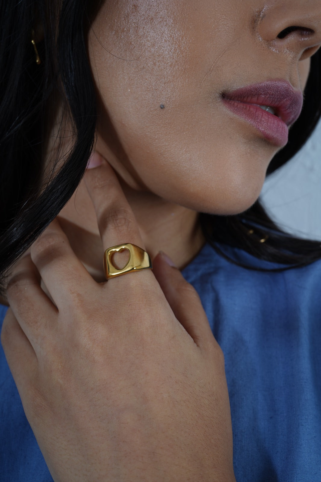 Close-up of a person wearing a gold ring with a heart design. | Statement Ring | Asymmetrical Ring  | neo jewelry 