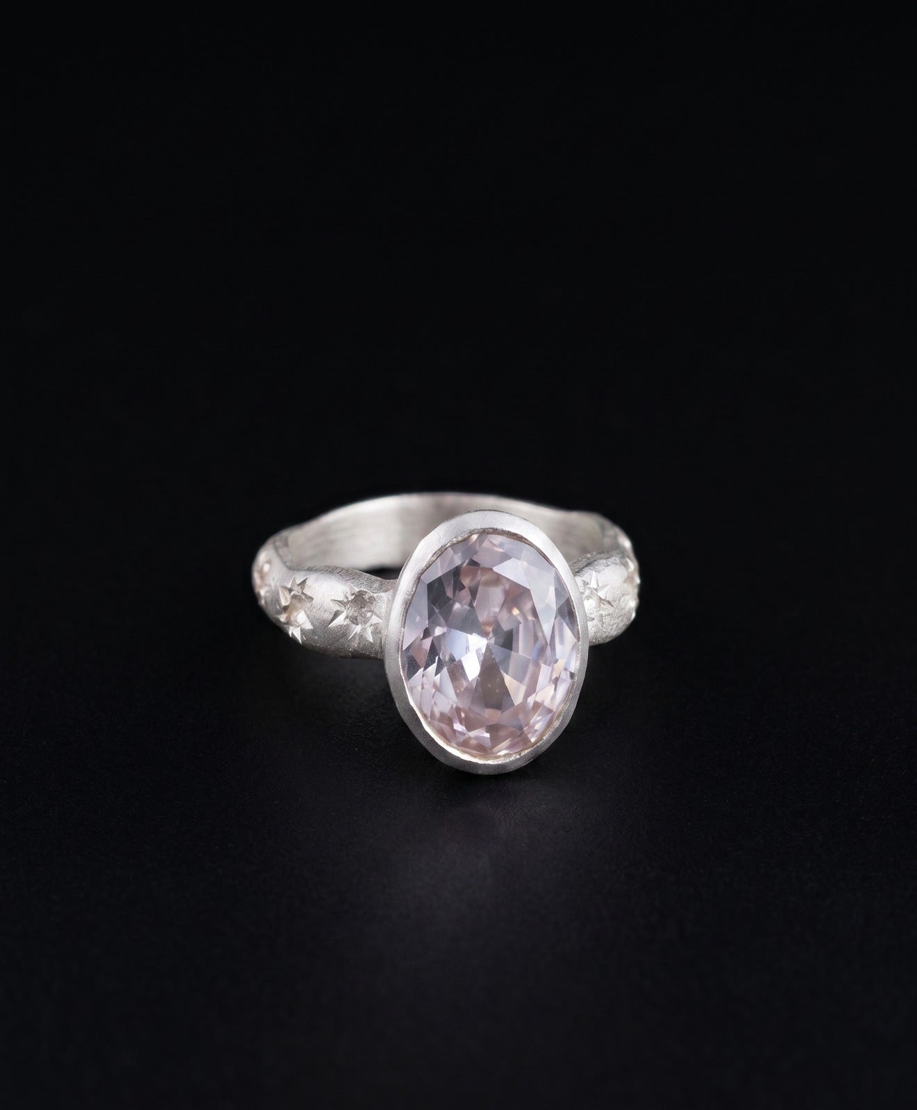 Near Earth Object | Silver ring with a pink gemstone on a black background