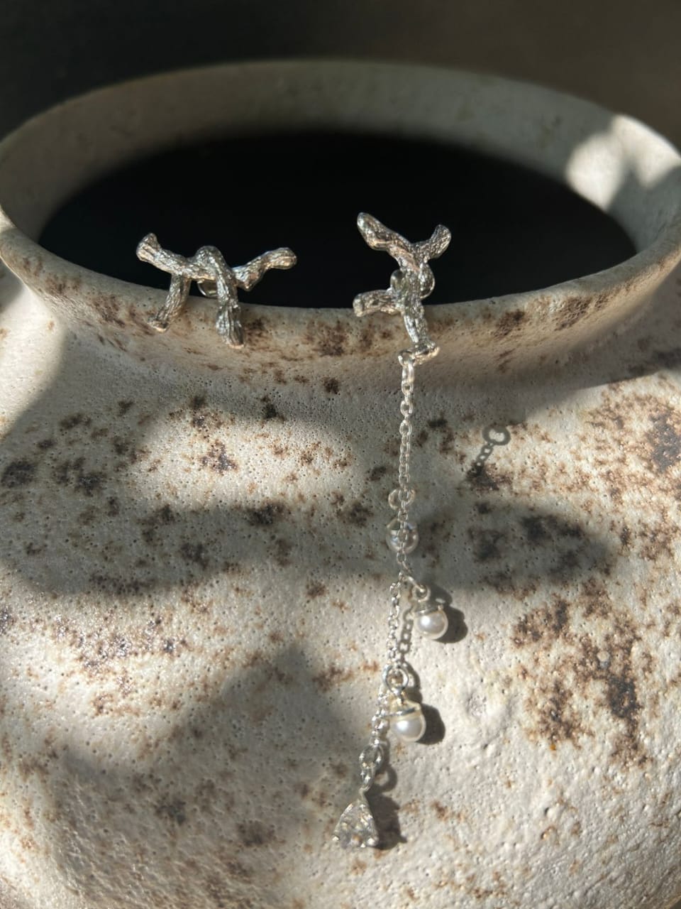 Silver earrings with dangling beads on a textured stone surface  | Statement Earrings | neo jewelry 