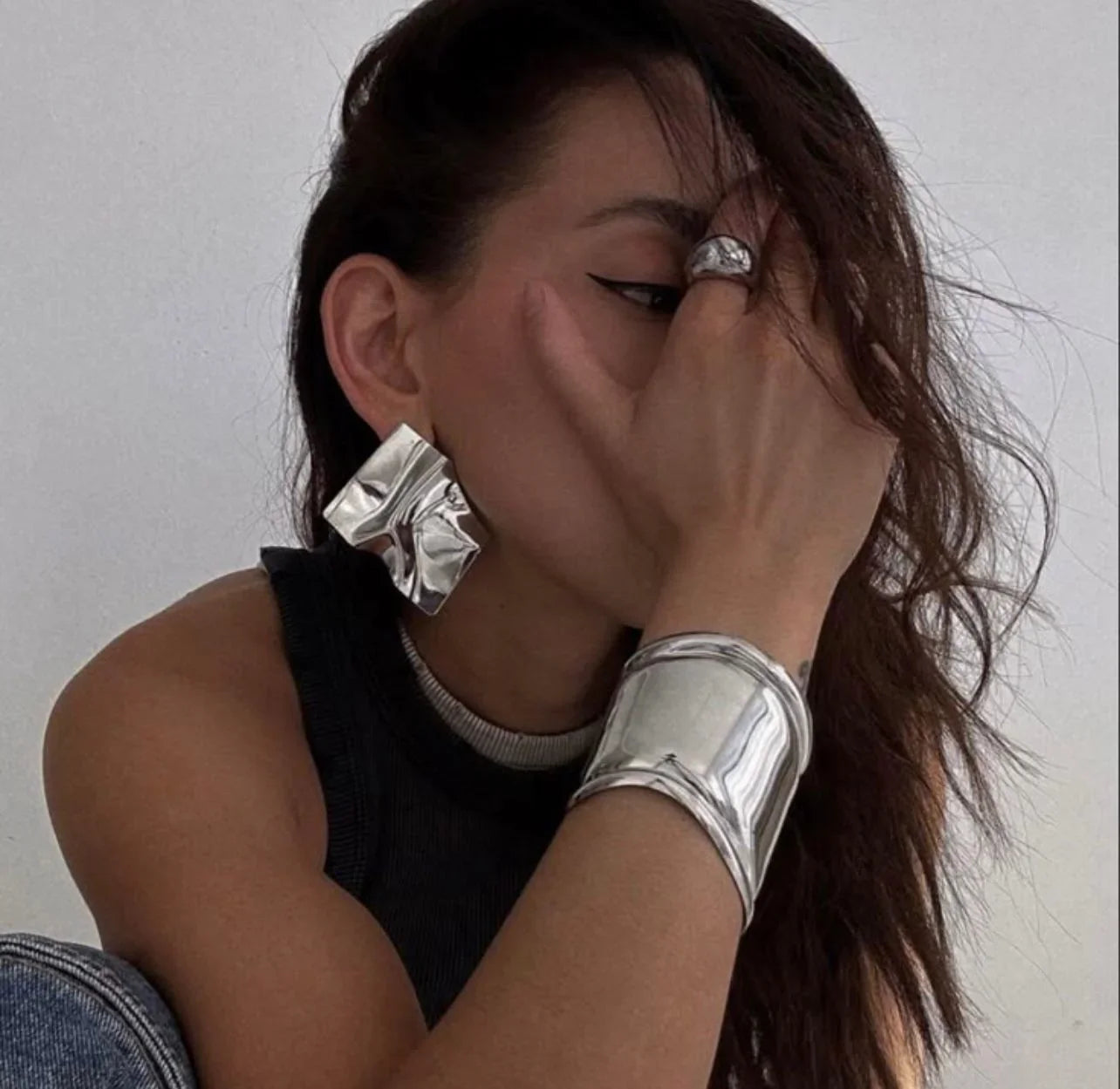 Person wearing silver earrings and silver handcuffs bracelet | Statement Handcuff | Bracelet | neo jewelry 