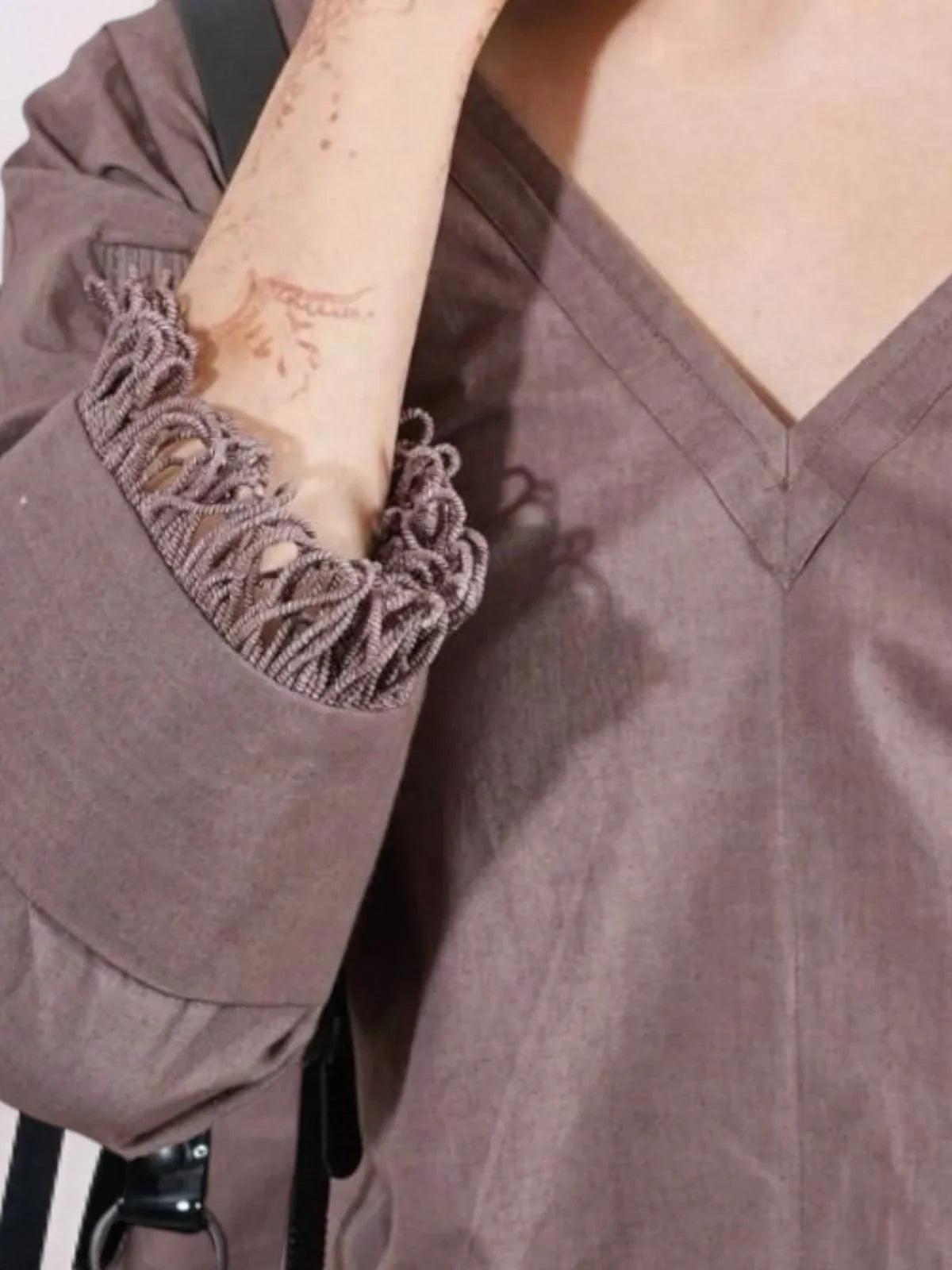 Close-up of a person wearing a beige v neck Jumpsuit with lace cuffs | Women Jumpsuit | Pret Clothes | nEo Clothes.