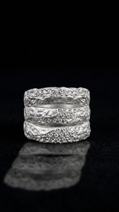 Near Earth Object |  silver rings with textured design on a black background