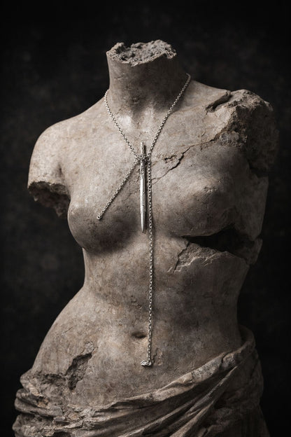 Near Earth Object | Stylized stone sculpture of a torso with a necklace on a dark background
