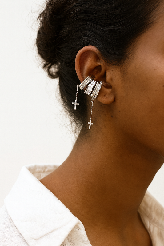 Model wearing layered silver ear cuffs with cross charm – sleek contemporary ear stack styling by Near Earth Object.